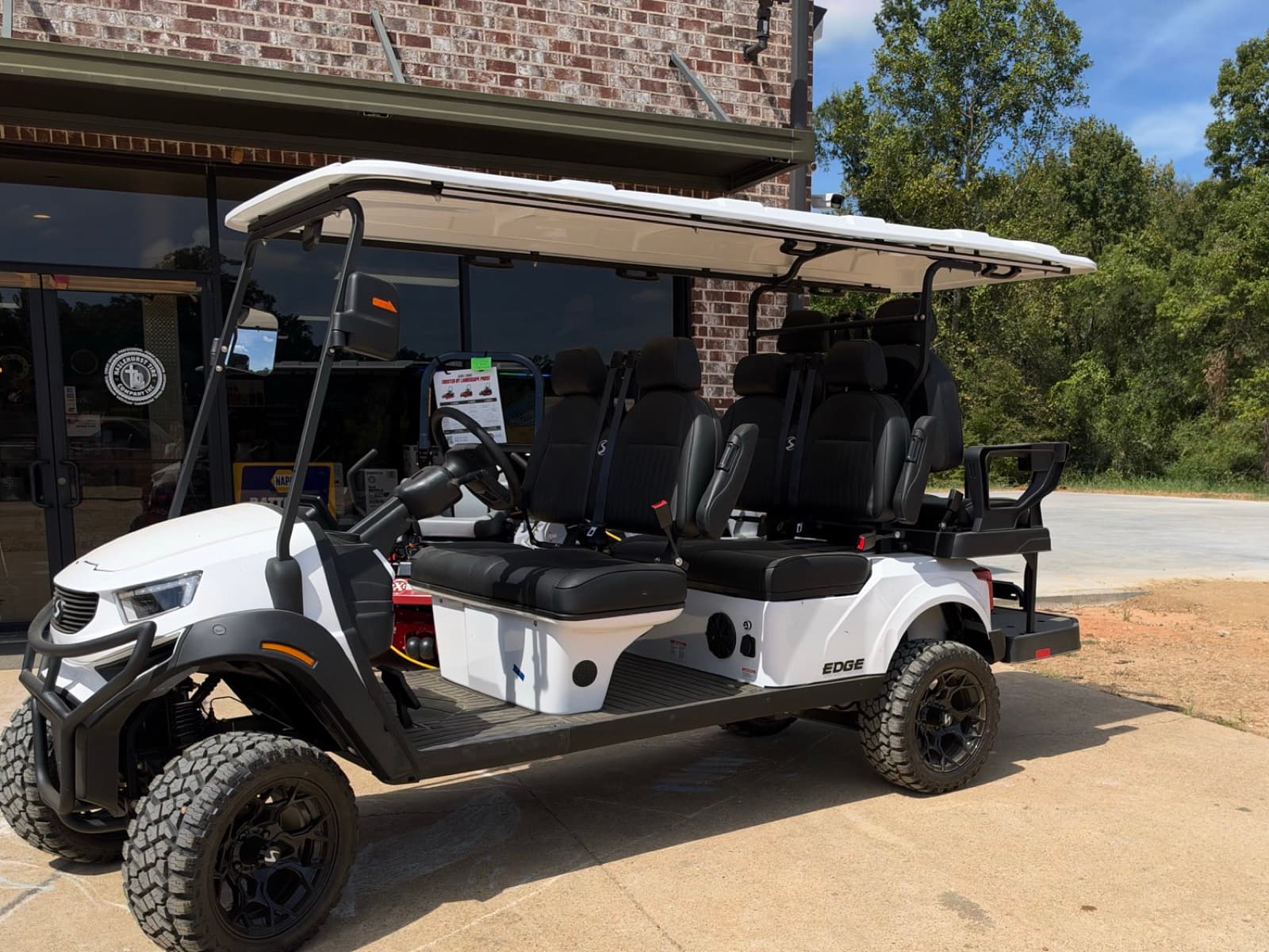 White SIVO Edge 6-passenger golf cart with a rear-facing seat at Hazlehurst Tire Company