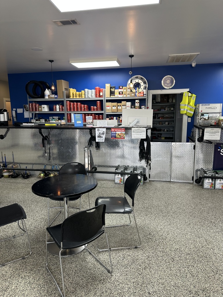 Service counter and waiting area with parts shelving along a blue wall at Hazlehurst Tire Company