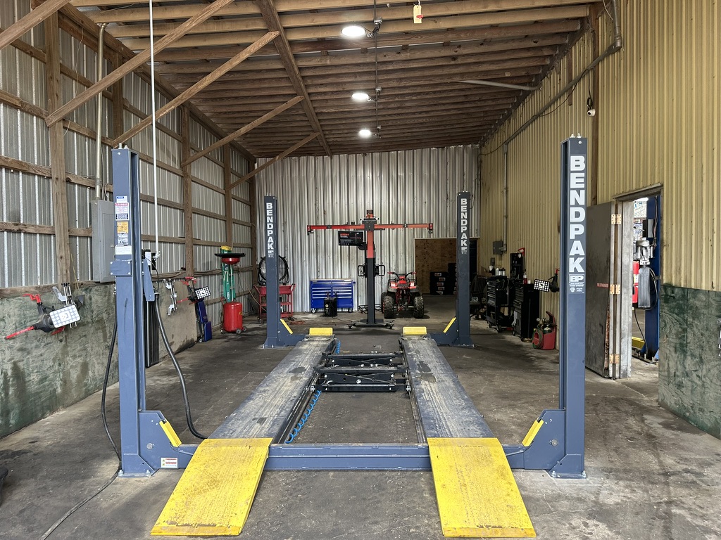 Empty BendPak four-post lift and wheel alignment equipment in a Hazlehurst Tire Company service bay