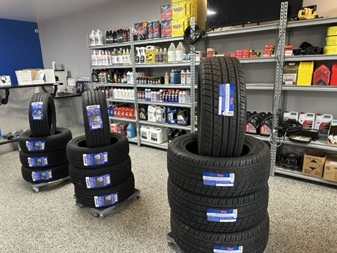 Stacks of new tires on wheeled dollies in front of parts shelving at Hazlehurst Tire Company