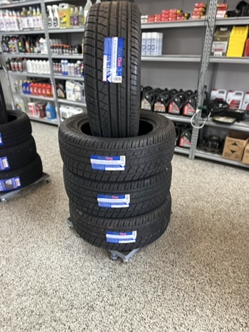 Close-up of new Tire One passenger tires stacked on a dolly in the Hazlehurst Tire Company showroom